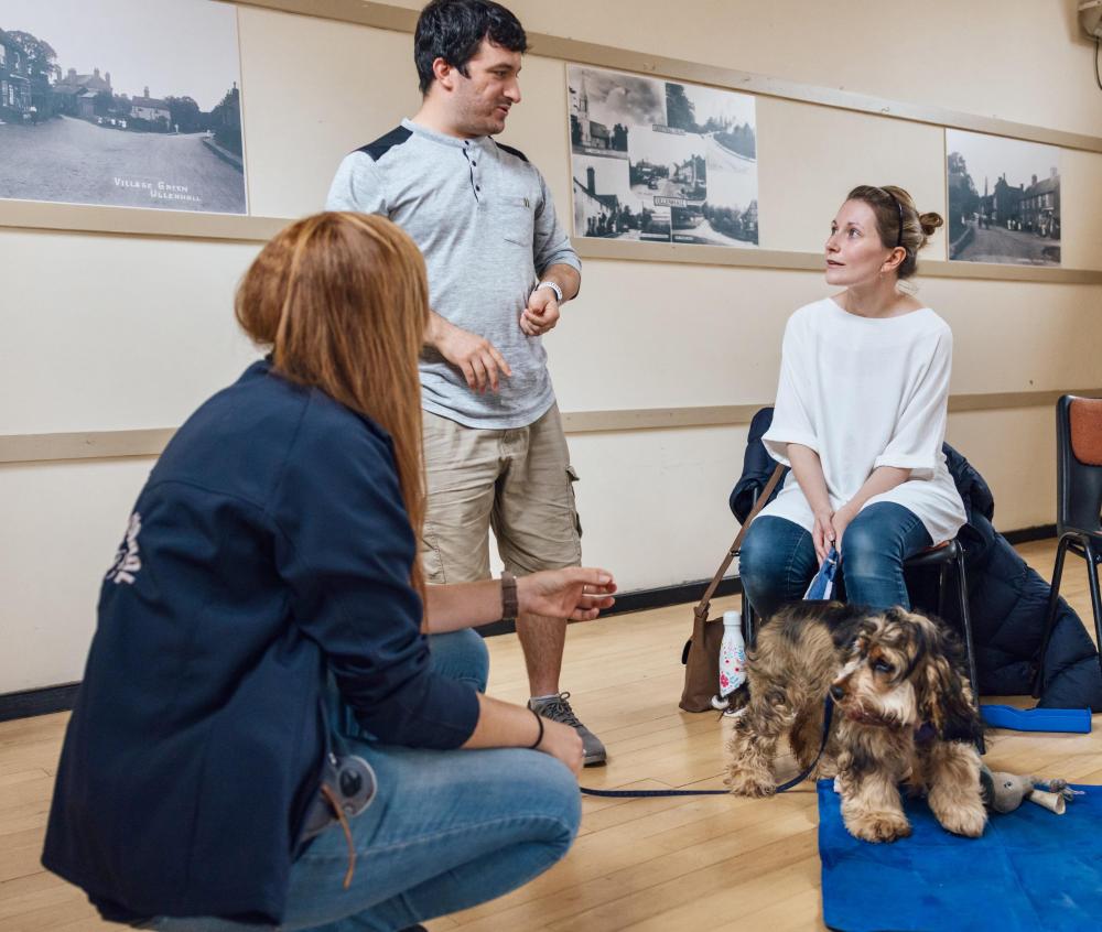 Puppy School tutor coaching their new dog owners in class