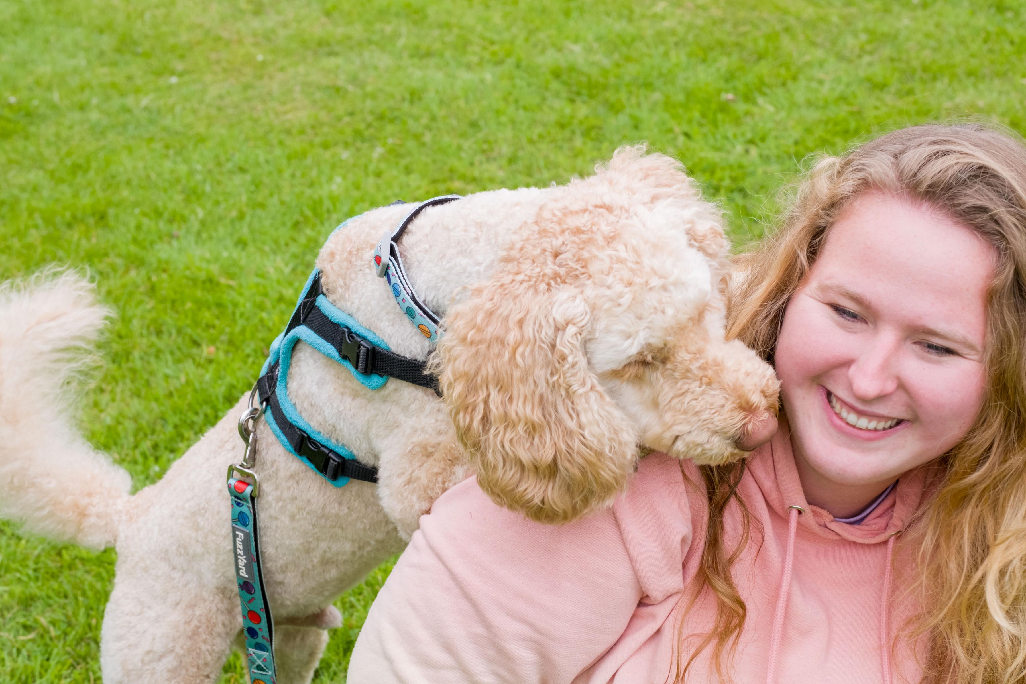 Puppy trainer Lilly Bell with her dog, Kevin, a golden labradoodle looking lovingly over her shoulder